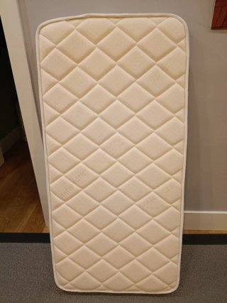 Cuna de madera con colchón y sábanas