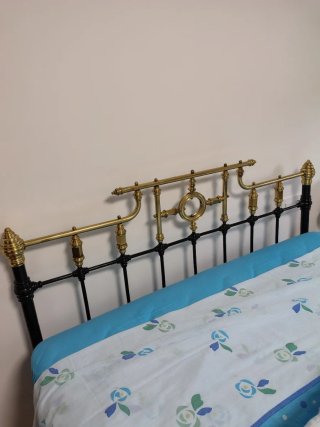 Cama de forja negra y dorada