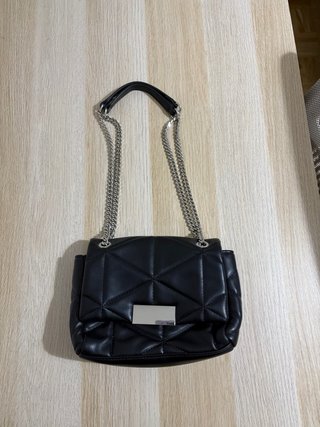 Bolso de cuero negro con asas de cadena