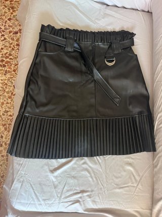 Falda de cuero negra con bajo plisado