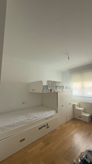Cama triple blanca con armarios y cajones.