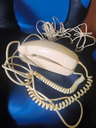 Teléfono antiguo beige con cable en espiral