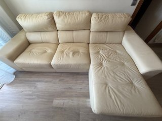 Sofá de piel beige claro com asientos extensibles