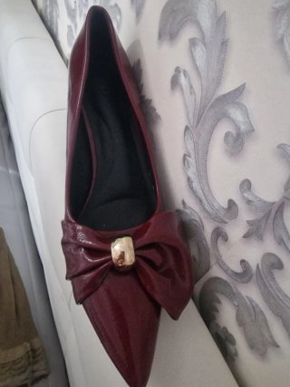 Zapatos de salón rojos con lazo dorado
