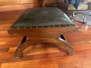 Poggiapiedi o pouf in pelle con borchie metalliche