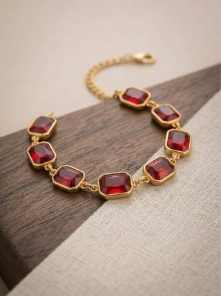 Bracciale con pietre rosse e finitura oro