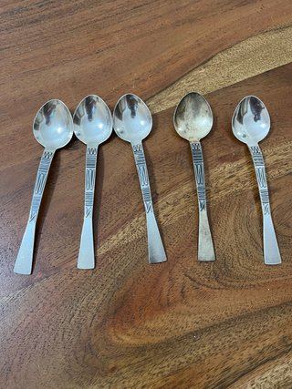 Cinco cucharas de metal plateado