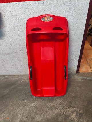 Trineo de plástico rojo con asas