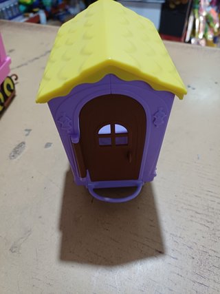 Casa de juguete morada con techo amarillo
