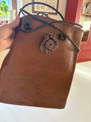 Bolso de piel marrón con flor de croché.