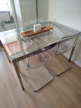 Set da pranzo con tavolo in cristallo e sedie in metacrilato