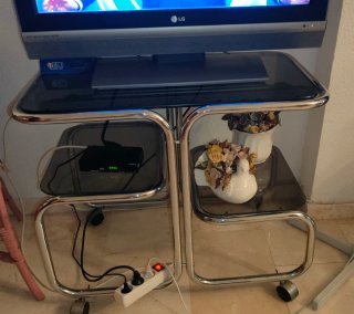 Mesa TV de cristal, metal y con ruedas. TV mando.