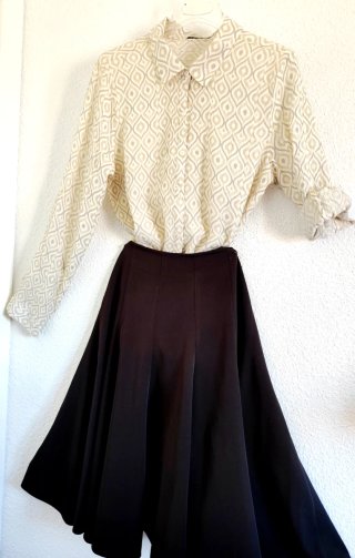 Blusa beige y falda marrón profundo.