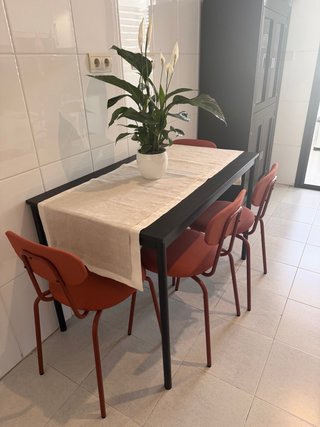 Mesa de comedor negra con sillas naranjas