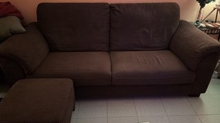 Sofá de dos plazas IKEA marrón y dos puffs.