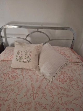 Cama niquelada antigua con colchón y colchas