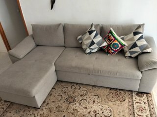 Sofá chaise longue gris con cama y arcón