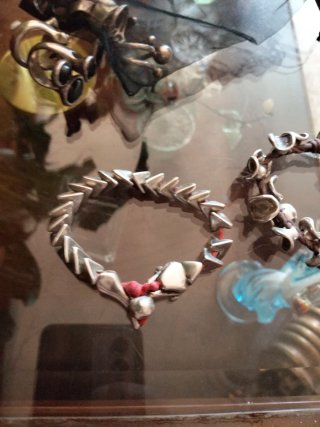 Pulseras plateadas con detalles rojos