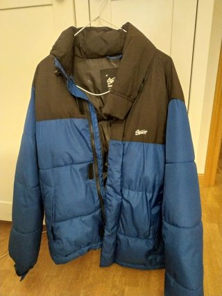 Plumífero azul y negro con capucha extraible
