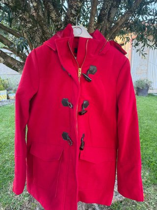 Abrigo rojo con capucha y botones.