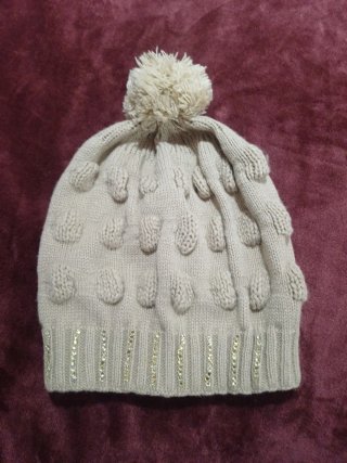 Gorro de punto beige con pompón