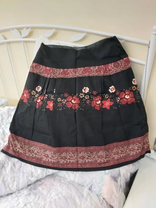 Falda negra con estampado floral, forrada.