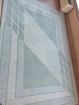 Alfombra beige y verde con diseño geométrico
