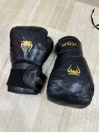 Guantes Venum negros y dorados para boxeo