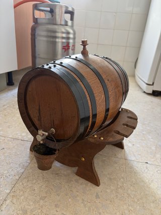 Barril de vino de madera con grifo y cubo
