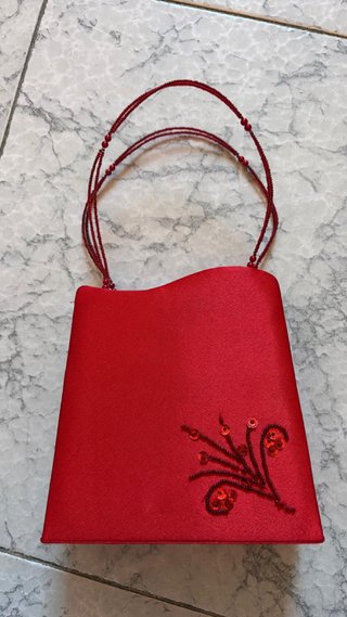 Bolso de mano rojo con diseño de flor