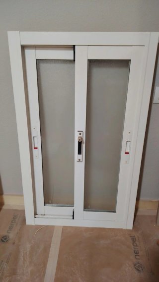 Ventana corredera blanca con vidrio esmerilado