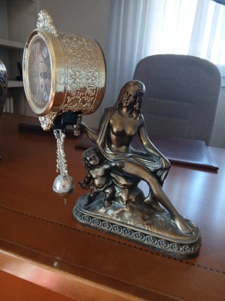Figura de mujer con niño y reloj
