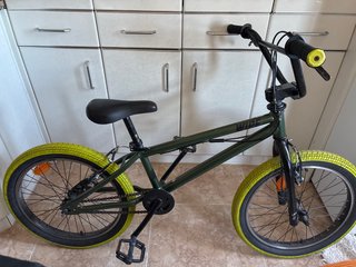 Bicicleta BMX verde con ruedas amarillas