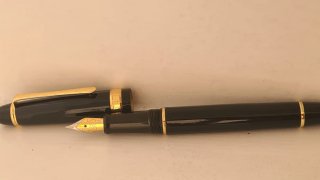 Pluma estilográfica negra con detalles dorados