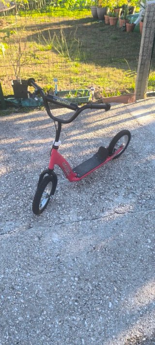 Patinete rojo con ruedas grandes