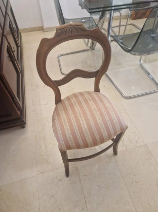 Silla de madera con tapizado floral.