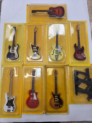 Pacchetto di strumenti musicali in miniatura: 8 chitarre + supporto mini