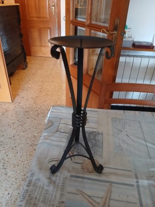 Candelabro de pie hierro forjado con tres pies.
