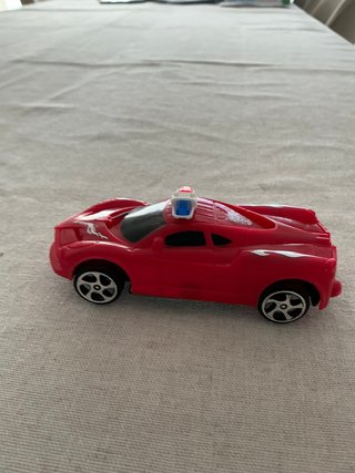 Coche de juguete rojo con cuerda