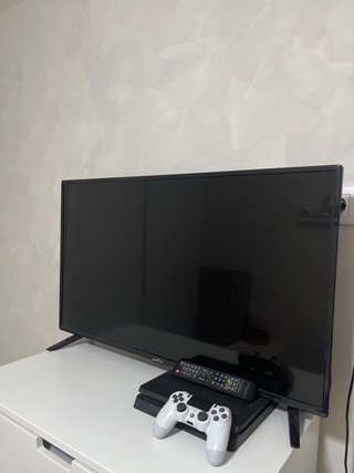 PS4 (PlayStation 4) con mando y televisión