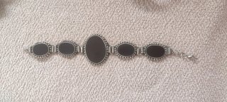 Pulsera con piedras negras y metal plateado