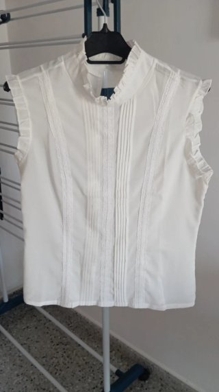 Blusa blanca sin mangas con detalles