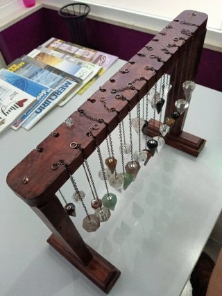 Expositor de madera con veintisiete péndulos