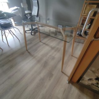 Mesa con sobre de cristal y patas de madera