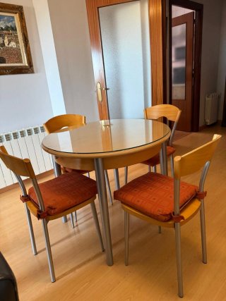 Mesa cocina redonda de madera extensible y sillas.