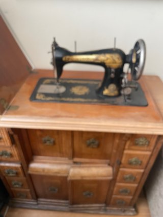 Máquina de coser antigua con mueble singer
