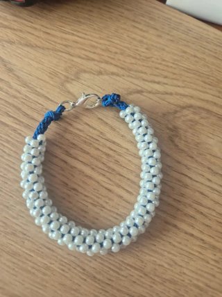 Pulsera artesanal de perlas blancas y cordón azul