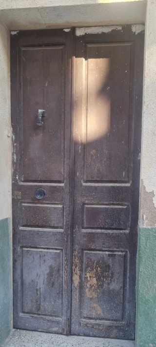 Puerta antigua de madera con picaporte.