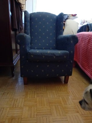 Sillón Orejero azul con motivos en amarillo.