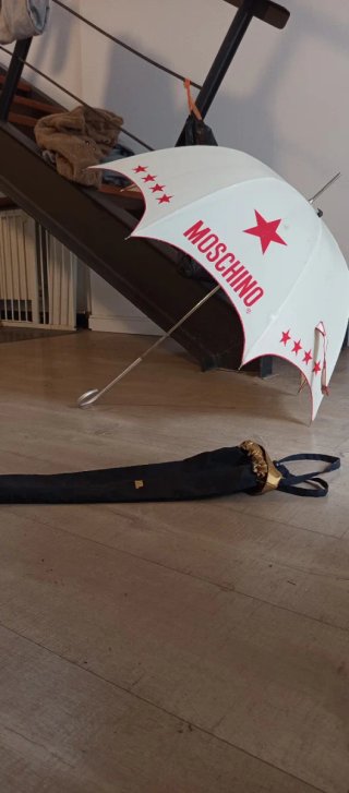 Paraguas Moschino color crema con letras en rojo